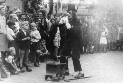 604781 Afbeelding Jo Wilbrink, verkleed als joker, tijdens een act met een baby die Adolf Hitler voorstelt, op het ...